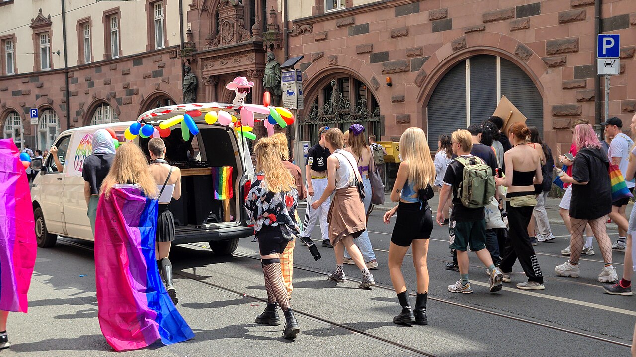 Teilnehmende beim Christopher Street Day in Frankfurt am Main mit Regenbogenfahnen.