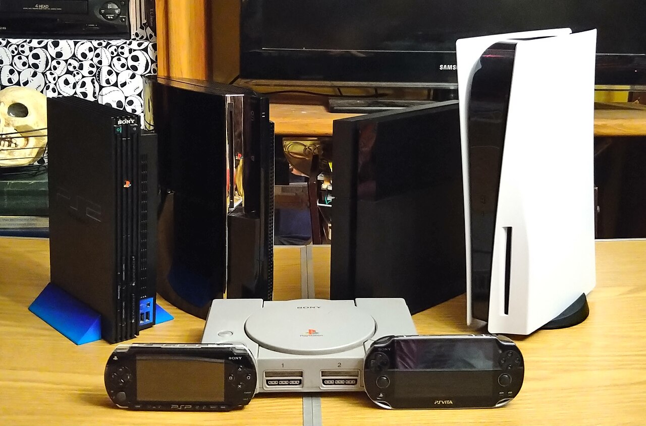Alle PlayStation-Konsolen von der ersten PlayStation bis zur PS5, dazu PSP und PS Vita, aufgereiht in einer Fotomontage.